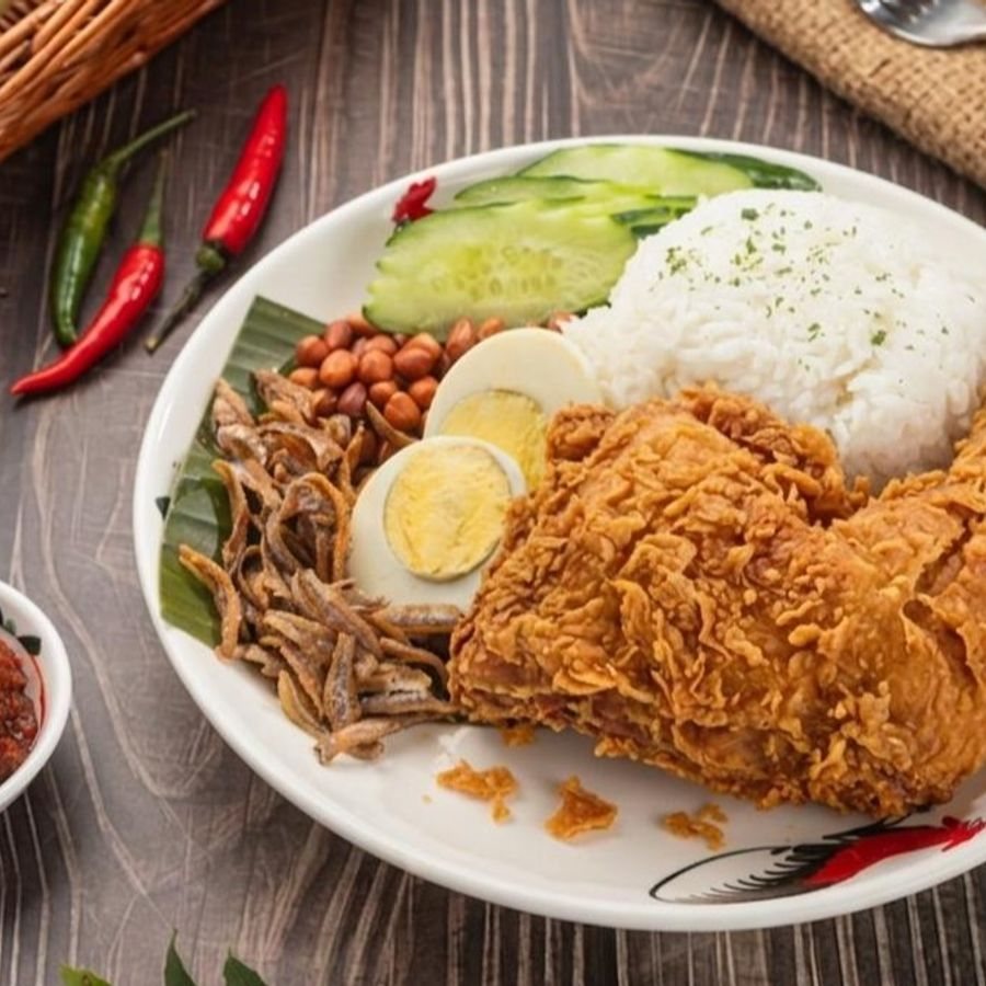 Nanyang Heritage crispy chicken nasi lemak with rice, egg, cucumber, peanuts and anchovies