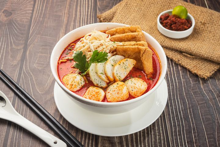 Singapore chicken laksa with shredded chicken, egg and fish cake