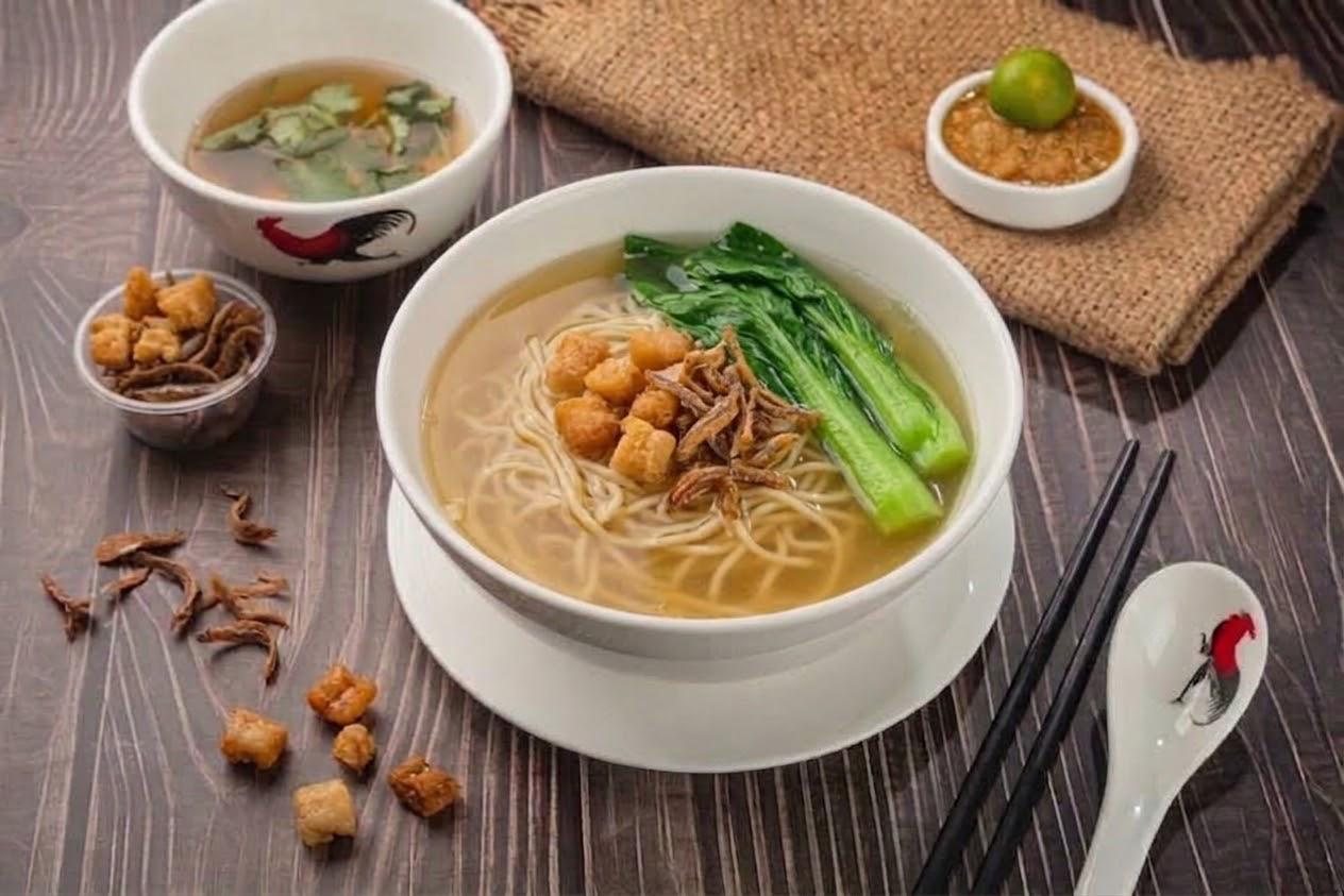 Thin noodles in chicken broth with leafy greens and crispy anchovies