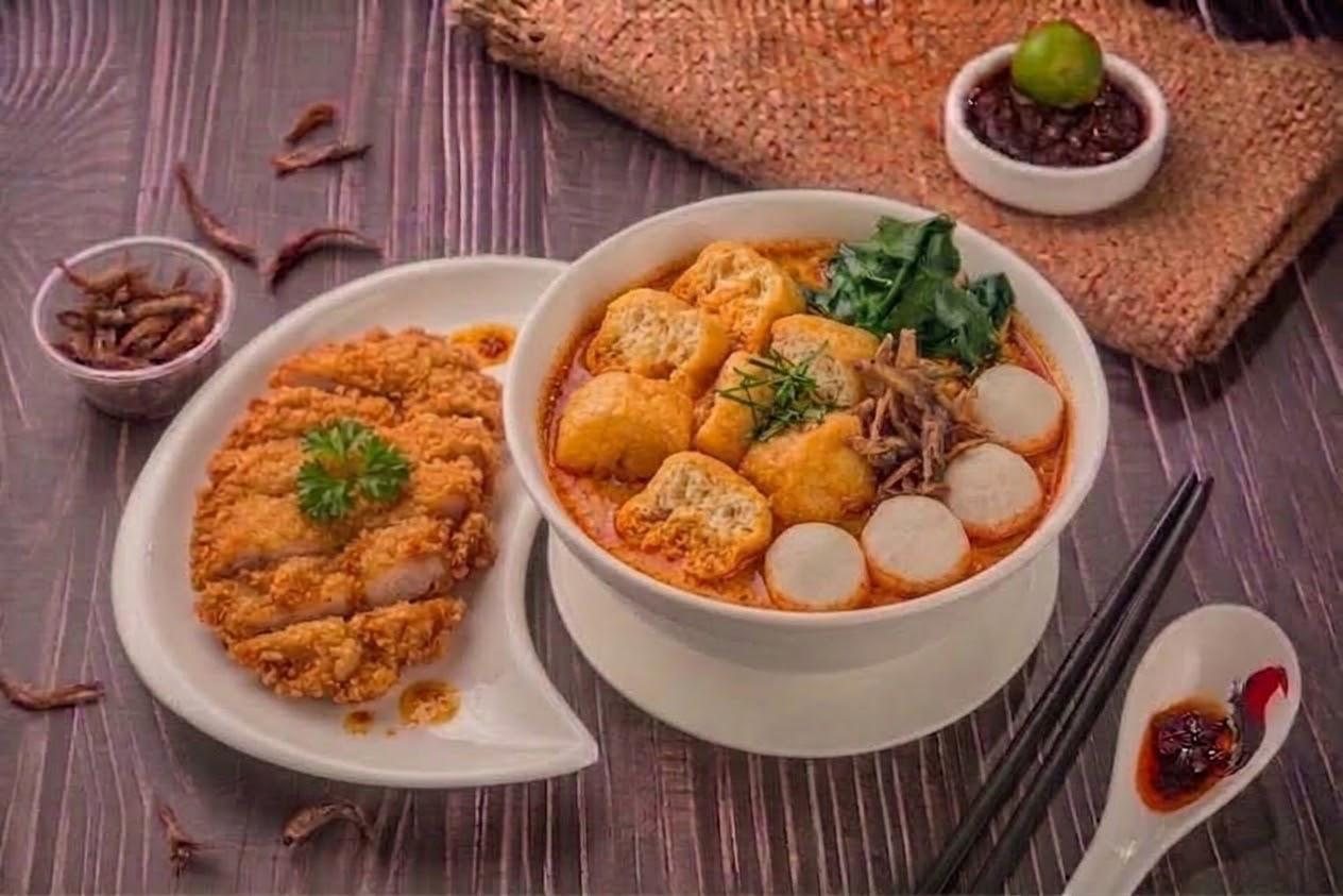 Ms Chin curry laksa ban mian with egg and greens, served with a crispy chicken cutlet