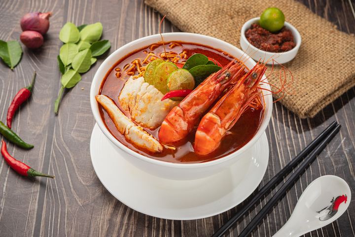 Penang prawn soup noodles topped with prawns, egg and greens